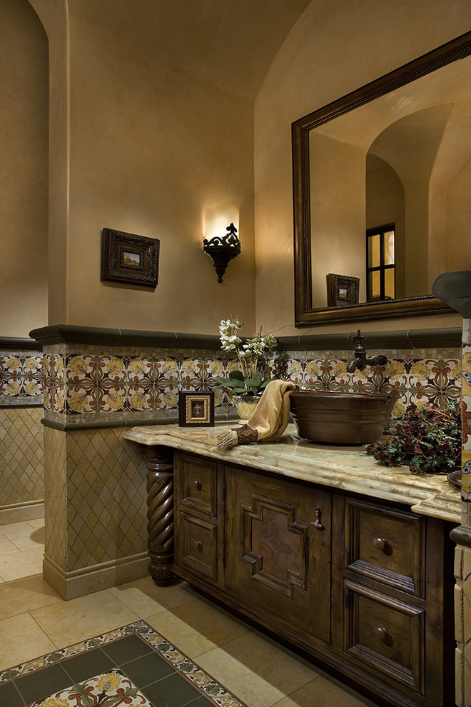 Exemple d'une très grande salle de bain principale méditerranéenne en bois clair avec un placard à porte plane, un bain bouillonnant, une douche double, WC à poser, un carrelage beige, un carrelage de pierre, un mur beige, un sol en travertin, un lavabo intégré et un plan de toilette en carrelage.
