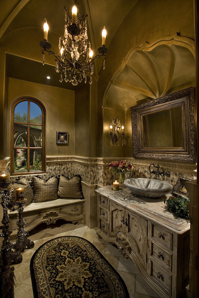 На фото: огромная главная ванная комната в средиземноморском стиле с плоскими фасадами, светлыми деревянными фасадами, гидромассажной ванной, двойным душем, унитазом-моноблоком, бежевой плиткой, каменной плиткой, бежевыми стенами, полом из травертина, монолитной раковиной и столешницей из плитки