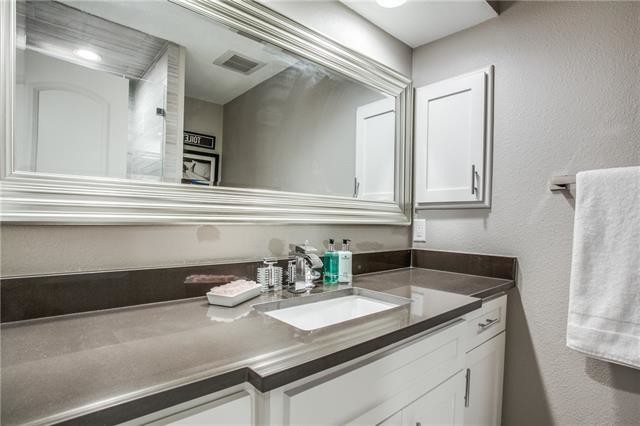 Medium sized classic family bathroom in Dallas with shaker cabinets, white cabinets, an alcove shower, a one-piece toilet, grey tiles, porcelain tiles, grey walls, porcelain flooring, a submerged sink and engineered stone worktops.