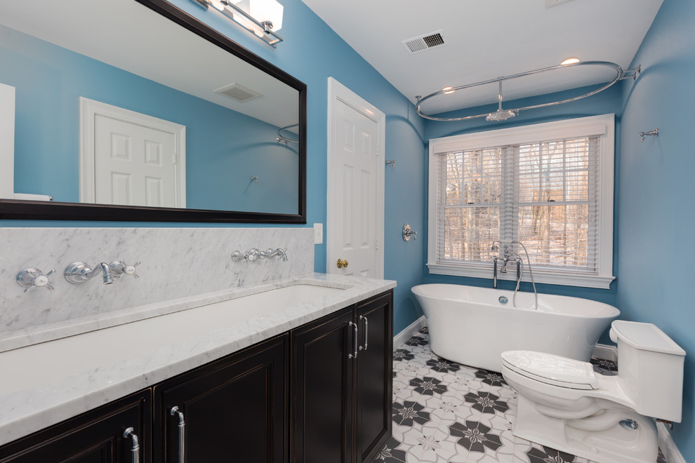 Идея дизайна: детская ванная комната среднего размера в современном стиле с фасадами с утопленной филенкой, темными деревянными фасадами, отдельно стоящей ванной, душем над ванной, унитазом-моноблоком, синими стенами, полом из керамической плитки, раковиной с несколькими смесителями, мраморной столешницей, разноцветным полом, шторкой для ванной и серой столешницей