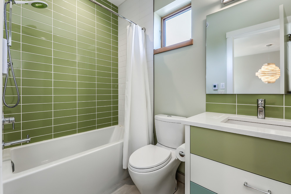 Cette photo montre une salle de bain rétro de taille moyenne avec un placard en trompe-l'oeil, des portes de placards vertess, une baignoire en alcôve, un combiné douche/baignoire, WC séparés, un carrelage vert, des carreaux de céramique, un mur vert, un sol en carrelage de porcelaine, un lavabo encastré, un sol blanc, une cabine de douche avec un rideau et un plan de toilette en quartz modifié.