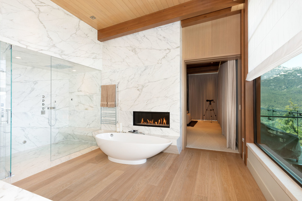 Modernes Badezimmer En Suite mit freistehender Badewanne, Duschnische, weißen Fliesen, Zementfliesen, braunem Holzboden, braunem Boden, Falttür-Duschabtrennung und weißer Waschtischplatte in Vancouver