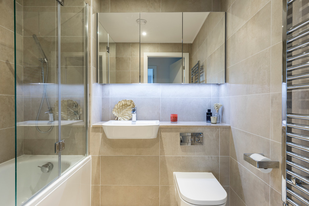 Idéer för att renovera ett mellanstort funkis badrum med dusch, med en dusch/badkar-kombination, en vägghängd toalettstol, beige kakel, porslinskakel, beige väggar, klinkergolv i porslin, ett nedsänkt handfat, släta luckor och ett badkar i en alkov