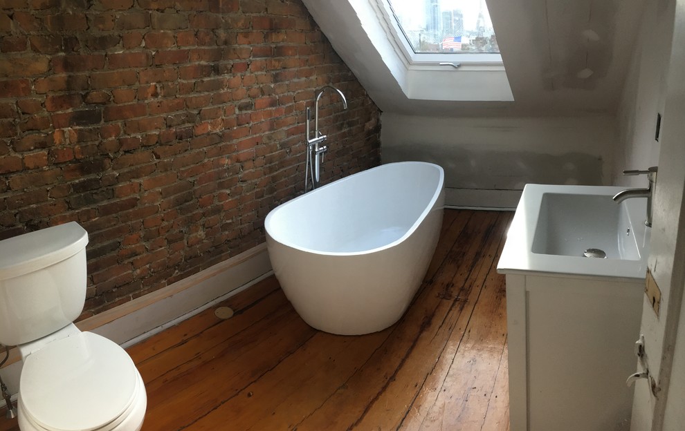 Inspiration for a medium sized industrial bathroom in Phoenix with shaker cabinets, white cabinets, a freestanding bath, a two-piece toilet, white walls, medium hardwood flooring, an integrated sink and engineered stone worktops.