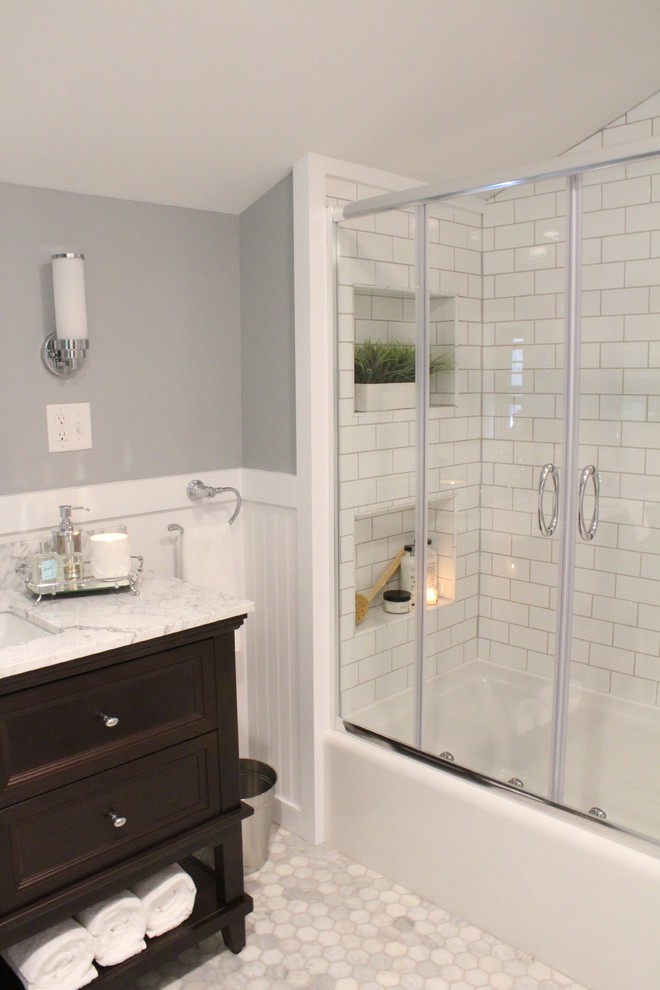 Пример оригинального дизайна: главная ванная комната среднего размера в классическом стиле с темными деревянными фасадами, ванной в нише, душем над ванной, раздельным унитазом, белой плиткой, плиткой кабанчик, серыми стенами, мраморным полом, врезной раковиной и мраморной столешницей