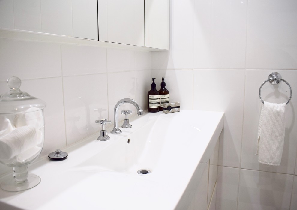 Aménagement d'une petite salle de bain classique avec une baignoire d'angle, un combiné douche/baignoire, WC à poser, un carrelage blanc, des carreaux de porcelaine, un mur blanc, un sol en carrelage de céramique et un plan vasque.