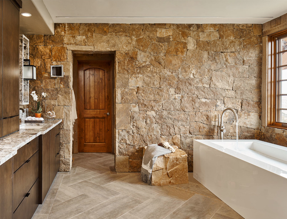 Aménagement d'une salle de bain principale montagne en bois foncé avec un placard à porte plane, une baignoire indépendante et un lavabo encastré.