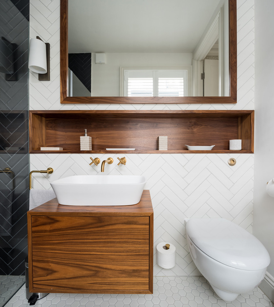 Inspiration for a contemporary shower room bathroom in Kent with flat-panel cabinets, medium wood cabinets, an alcove shower, a wall mounted toilet, black and white tiles, metro tiles, white walls, porcelain flooring, a vessel sink, wooden worktops, white floors, a hinged door and brown worktops.