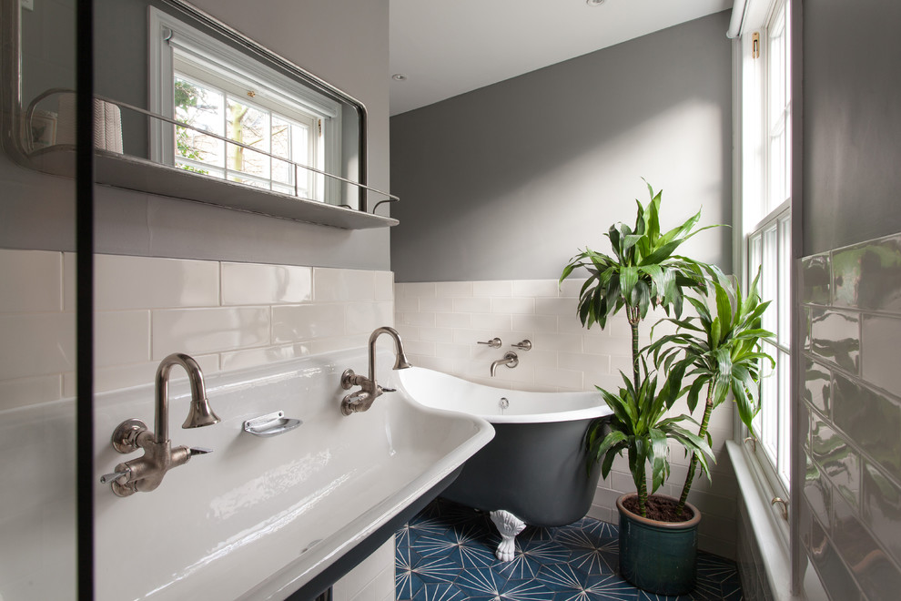 На фото: ванная комната в стиле неоклассика (современная классика) с ванной на ножках, белой плиткой, плиткой кабанчик, серыми стенами, душевой кабиной, раковиной с несколькими смесителями и синим полом с