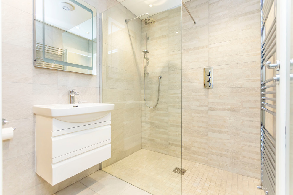 Inspiration for a medium sized beach style ensuite bathroom in Hampshire with raised-panel cabinets, white cabinets, a built-in shower, a one-piece toilet, beige tiles, ceramic tiles, beige walls, porcelain flooring, an integrated sink, solid surface worktops, beige floors, an open shower and beige worktops.