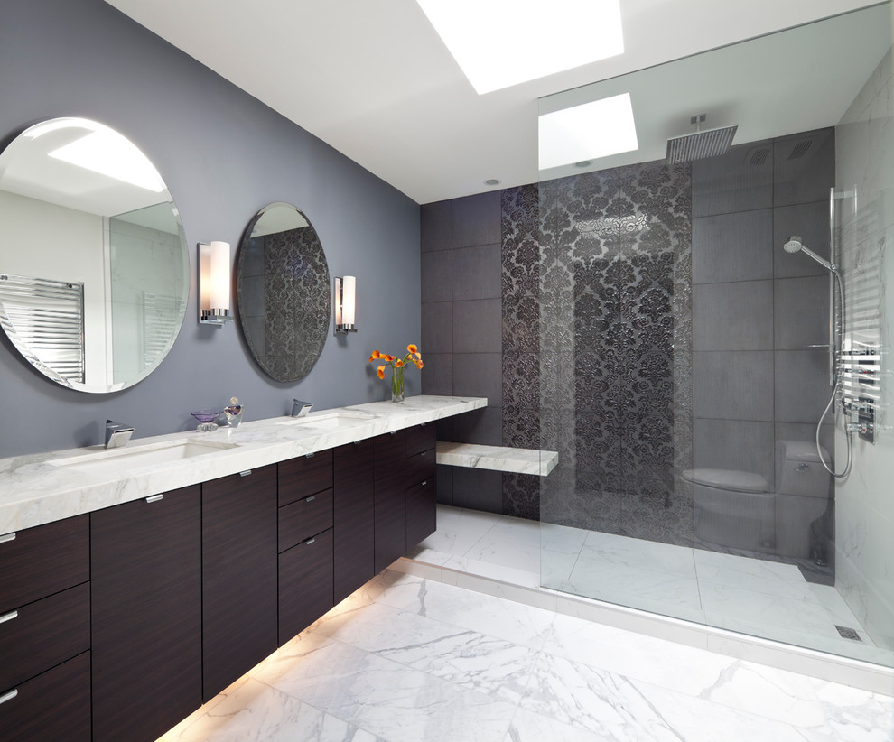 Aménagement d'une salle de bain contemporaine en bois foncé avec un placard à porte plane et un carrelage gris.