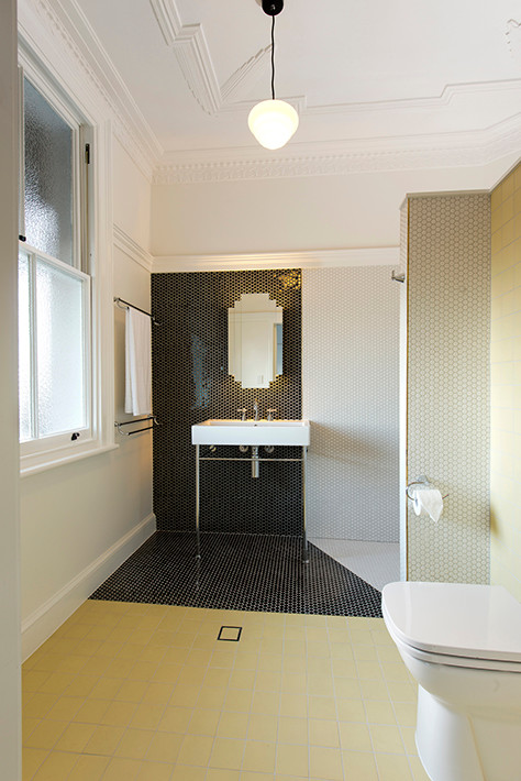 Стильный дизайн: главная ванная комната в стиле модернизм с стеклянными фасадами, раздельным унитазом, черно-белой плиткой, керамической плиткой, белыми стенами, полом из керамической плитки, раковиной с пьедесталом и желтым полом - последний тренд