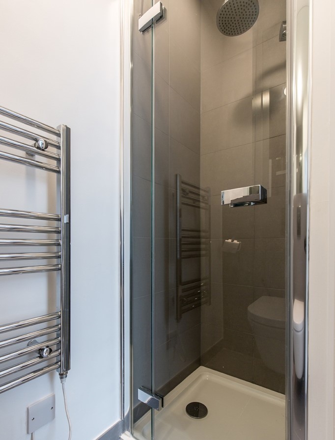 Mittelgroßes Modernes Badezimmer En Suite mit bodengleicher Dusche, Wandtoilette, grauen Fliesen, Porzellanfliesen, weißer Wandfarbe, Porzellan-Bodenfliesen, Wandwaschbecken, grauem Boden und Falttür-Duschabtrennung in London