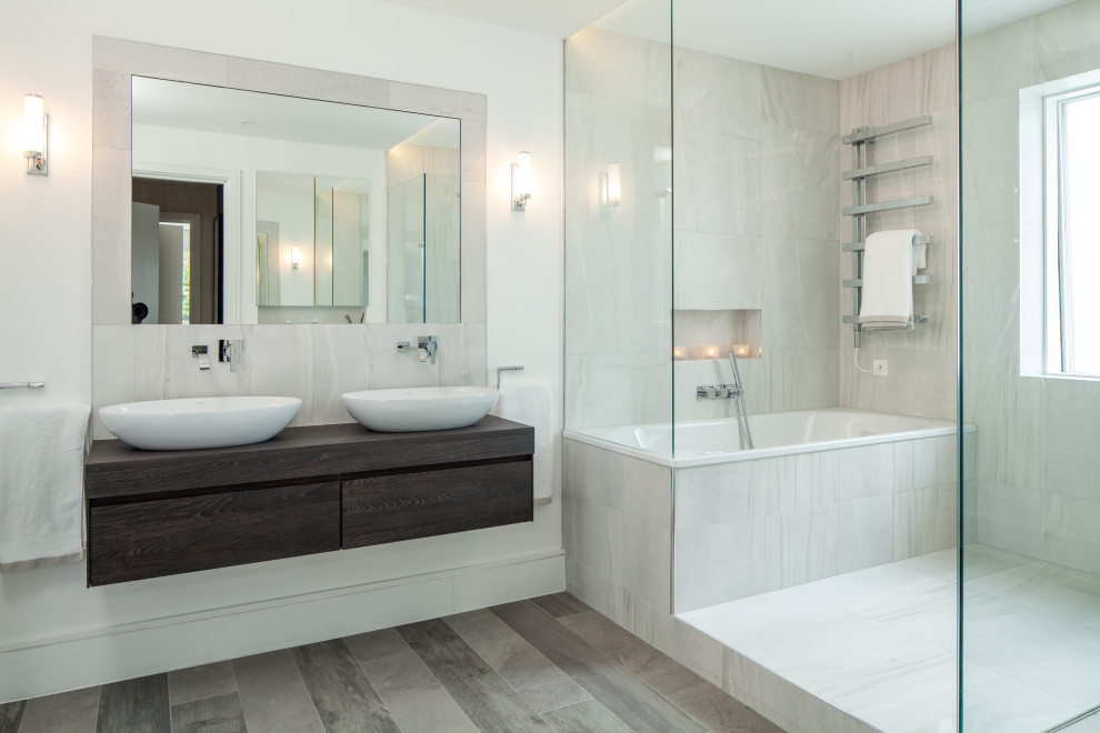 Aménagement d'une salle de bain principale contemporaine en bois foncé avec un placard à porte plane, une baignoire posée, un espace douche bain, un carrelage gris, un mur blanc, une vasque, un plan de toilette en bois, un sol marron et un plan de toilette marron.