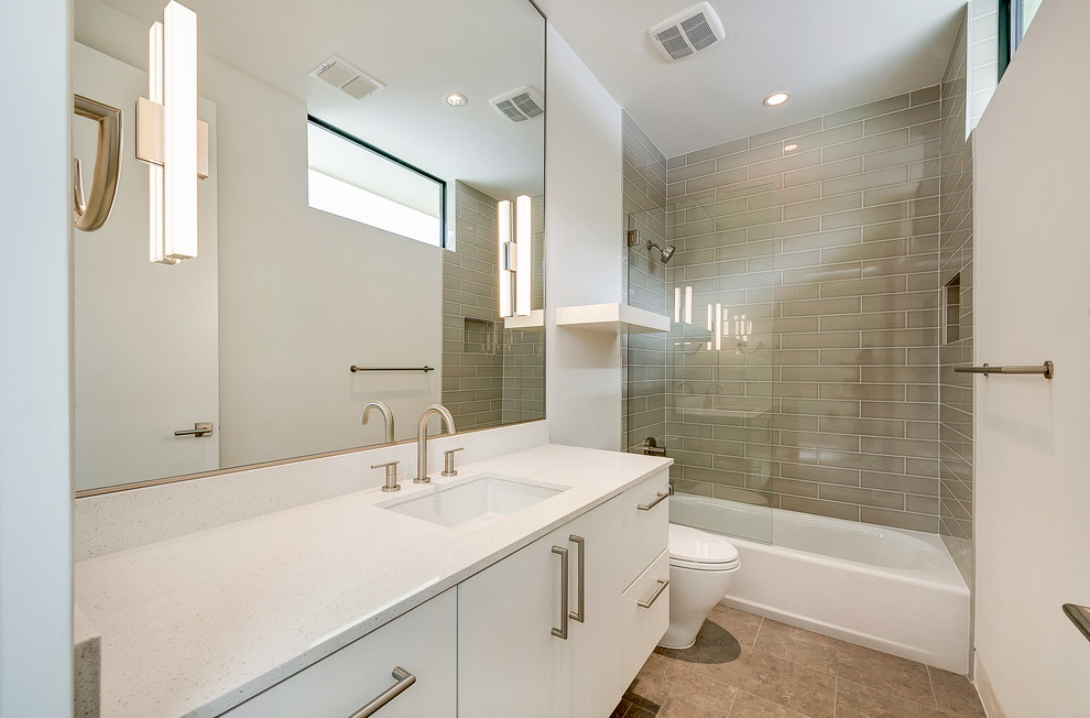 Immagine di una stanza da bagno minimalista con lavabo sottopiano, ante lisce, ante bianche, top in quarzite, vasca ad alcova, WC a due pezzi, piastrelle grigie, pareti bianche e pavimento in gres porcellanato