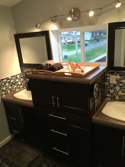 Inredning av ett modernt litet badrum, med skåp i shakerstil, svarta skåp, en toalettstol med separat cisternkåpa, svart och vit kakel, glasskiva, grå väggar, betonggolv, ett nedsänkt handfat och bänkskiva i betong