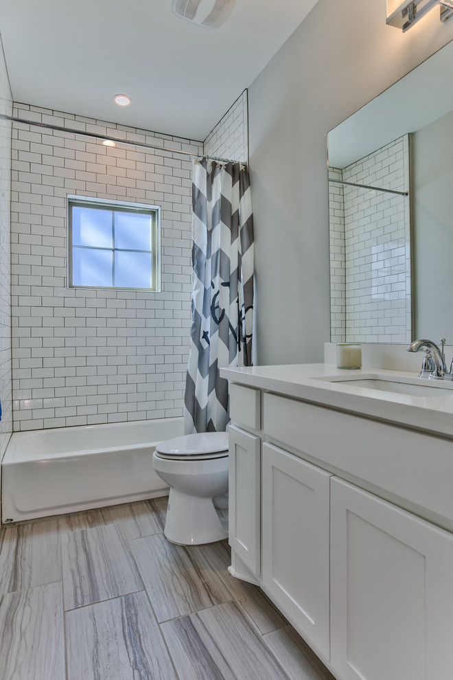 Exempel på ett mellanstort amerikanskt badrum med dusch, med skåp i shakerstil, vita skåp, ett badkar i en alkov, en dusch/badkar-kombination, vit kakel, keramikplattor, grå väggar, klinkergolv i porslin, ett undermonterad handfat och bänkskiva i kvarts