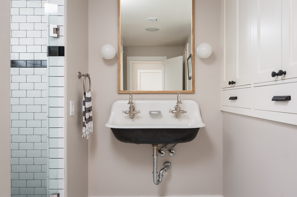 На фото: ванная комната в стиле кантри с черной плиткой, черно-белой плиткой, белой плиткой, серыми стенами и раковиной с несколькими смесителями