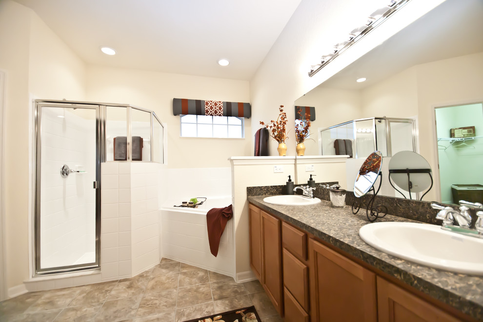 Réalisation d'une salle de bain principale en bois brun de taille moyenne avec un lavabo posé, un placard avec porte à panneau encastré, un plan de toilette en stratifié, une baignoire d'angle, un carrelage beige, un mur blanc et un sol en linoléum.