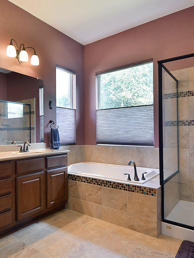 Photo of a large contemporary ensuite bathroom in Austin with raised-panel cabinets, medium wood cabinets, a built-in bath, a corner shower, brown tiles, ceramic tiles, brown walls, ceramic flooring, a submerged sink, brown floors and a hinged door.