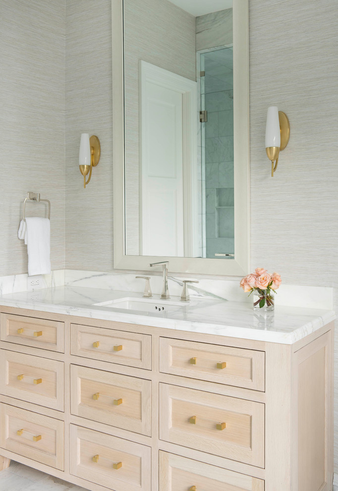 Idée de décoration pour une salle de bain méditerranéenne en bois clair avec un lavabo encastré, un plan de toilette en marbre, un plan de toilette blanc, un mur gris et un placard à porte shaker.