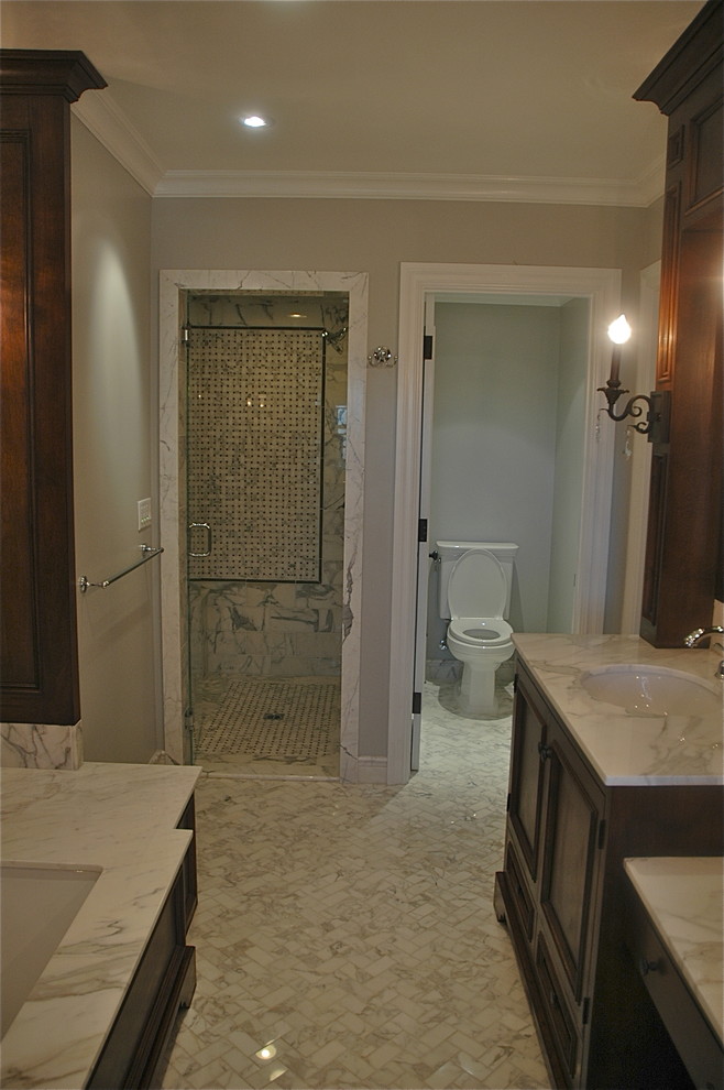 Medium sized traditional bathroom in Los Angeles with a submerged sink, a submerged bath, a two-piece toilet, dark wood cabinets, marble worktops, white tiles, stone tiles, recessed-panel cabinets and ceramic flooring.
