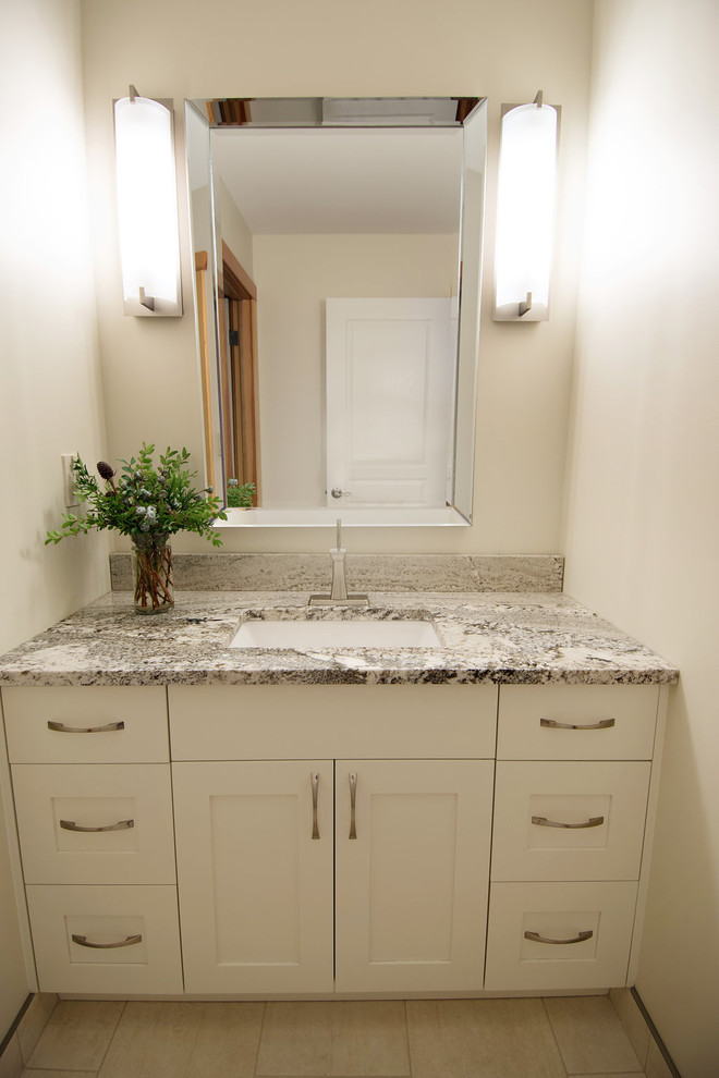 Foto på ett mellanstort vintage badrum, med skåp i shakerstil, vita skåp, beige kakel, porslinskakel, vita väggar, klinkergolv i porslin, ett undermonterad handfat och granitbänkskiva