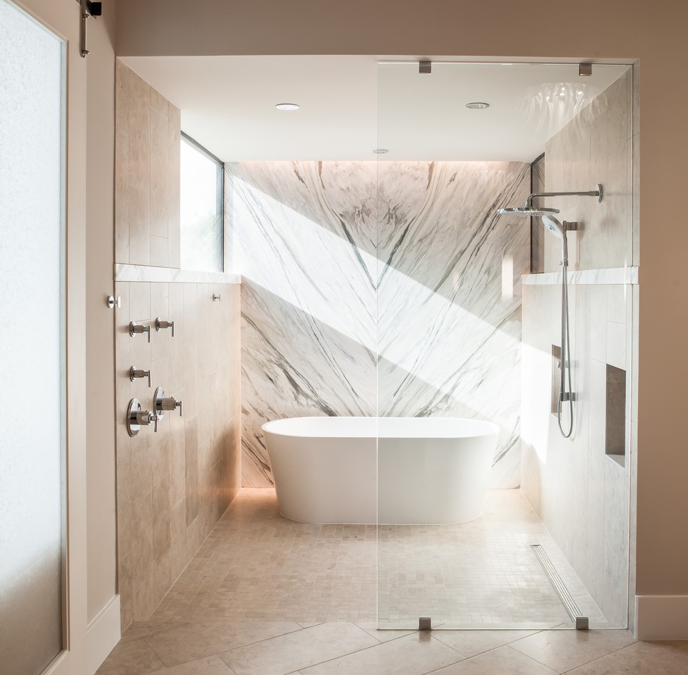 Стильный дизайн: ванная комната в современном стиле с отдельно стоящей ванной, душем без бортиков, серой плиткой, бежевыми стенами и окном - последний тренд