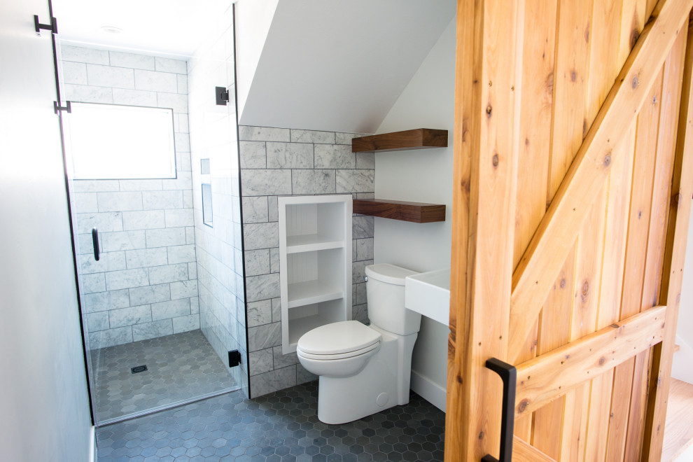 Стильный дизайн: маленькая ванная комната в стиле неоклассика (современная классика) с белыми фасадами, душем без бортиков, раздельным унитазом, белой плиткой, каменной плиткой, белыми стенами, полом из мозаичной плитки, подвесной раковиной, черным полом, душем с распашными дверями, нишей, тумбой под одну раковину и подвесной тумбой для на участке и в саду - последний тренд