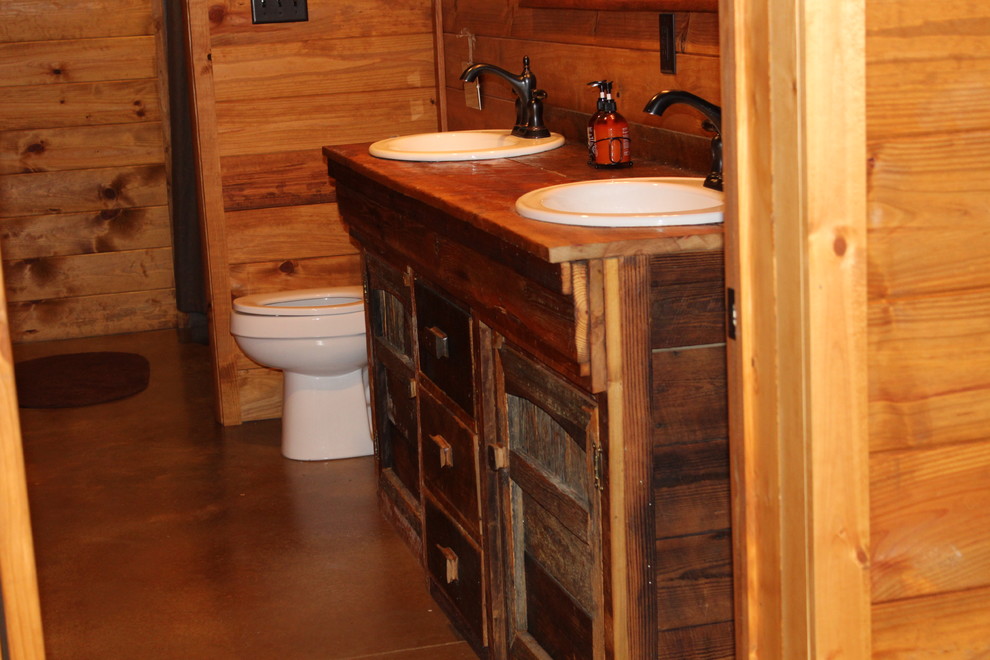 Inspiration for a medium sized rustic family bathroom in Atlanta with freestanding cabinets, distressed cabinets, an alcove bath, a shower/bath combination, a two-piece toilet, multi-coloured tiles, slate tiles, brown walls, concrete flooring, a built-in sink, granite worktops, brown floors, a shower curtain and brown worktops.