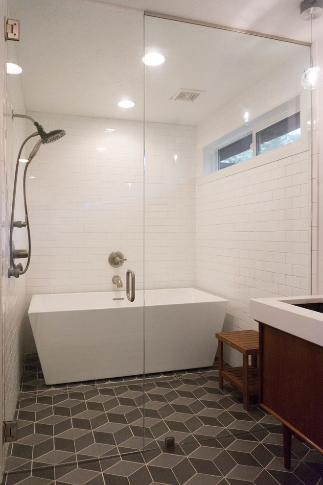 Bild på ett mellanstort retro en-suite badrum, med ett fristående badkar, en kantlös dusch, en toalettstol med hel cisternkåpa, vit kakel, kakel i småsten, vita väggar, klinkergolv i porslin och ett undermonterad handfat