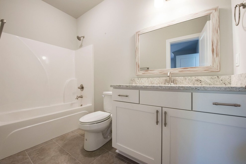 Example of a mid-sized country kids' porcelain tile and beige floor bathroom design in Atlanta with recessed-panel cabinets, white cabinets, a two-piece toilet, gray walls, an undermount sink, granite countertops and white countertops