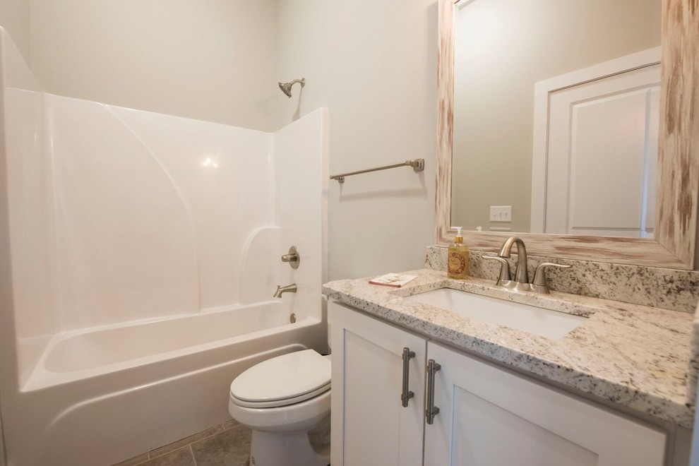 Mid-sized country 3/4 travertine floor and beige floor bathroom photo in Atlanta with shaker cabinets, white cabinets, a two-piece toilet, beige walls, an undermount sink and granite countertops