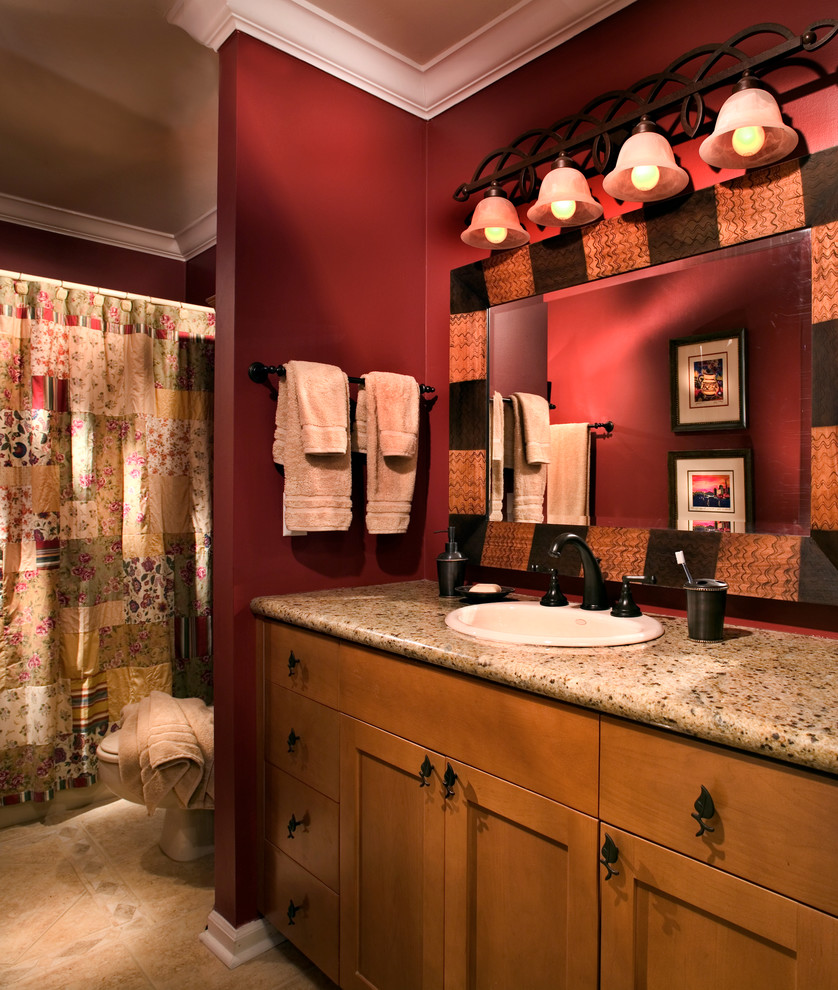 Idée de décoration pour une salle de bain craftsman en bois brun de taille moyenne pour enfant avec un placard à porte shaker, une baignoire posée, un combiné douche/baignoire, WC séparés, un carrelage beige, des carreaux de céramique, un mur rouge, un sol en carrelage de céramique, un lavabo posé et un plan de toilette en granite.