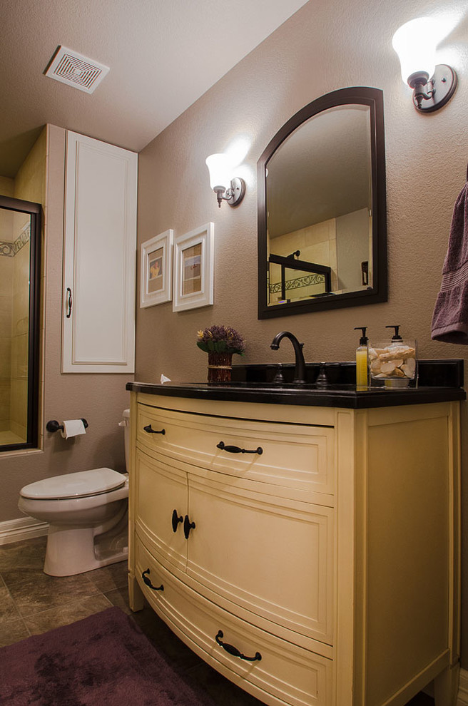 Bild på ett mellanstort vintage badrum, med möbel-liknande, gula skåp, en dusch i en alkov, en toalettstol med separat cisternkåpa, bruna väggar, skiffergolv, ett undermonterad handfat och granitbänkskiva