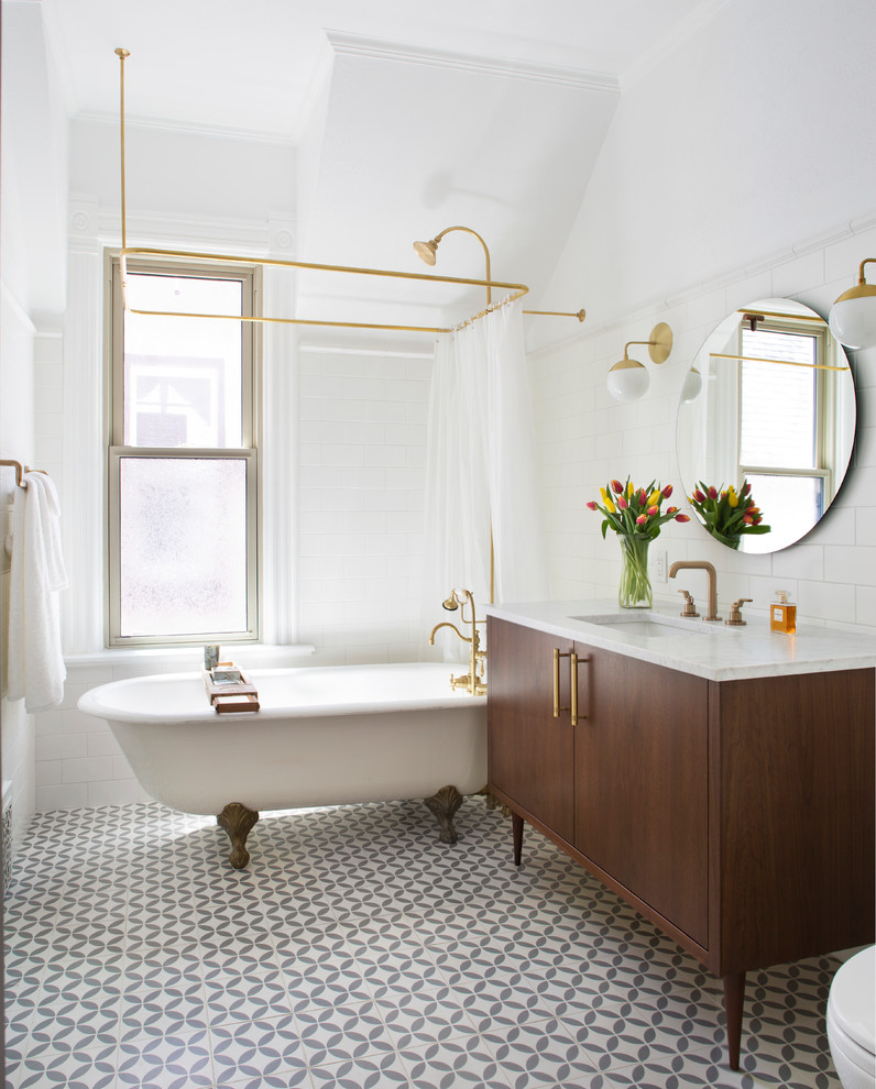 Inredning av ett klassiskt litet vit vitt en-suite badrum, med bruna skåp, ett badkar med tassar, en dusch/badkar-kombination, vit kakel, tunnelbanekakel, vita väggar, marmorbänkskiva, grått golv, dusch med duschdraperi, ett undermonterad handfat och släta luckor