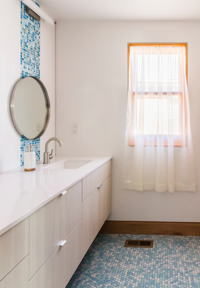 Пример оригинального дизайна: ванная комната в современном стиле с плоскими фасадами, светлыми деревянными фасадами и полом из мозаичной плитки