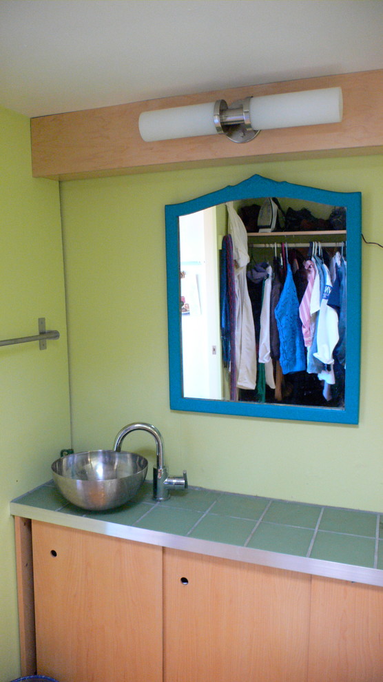 Idéer för ett litet eklektiskt badrum med dusch, med ett fristående handfat, släta luckor, skåp i ljust trä, kaklad bänkskiva, en toalettstol med separat cisternkåpa, grön kakel, glaskakel, gröna väggar och klinkergolv i keramik
