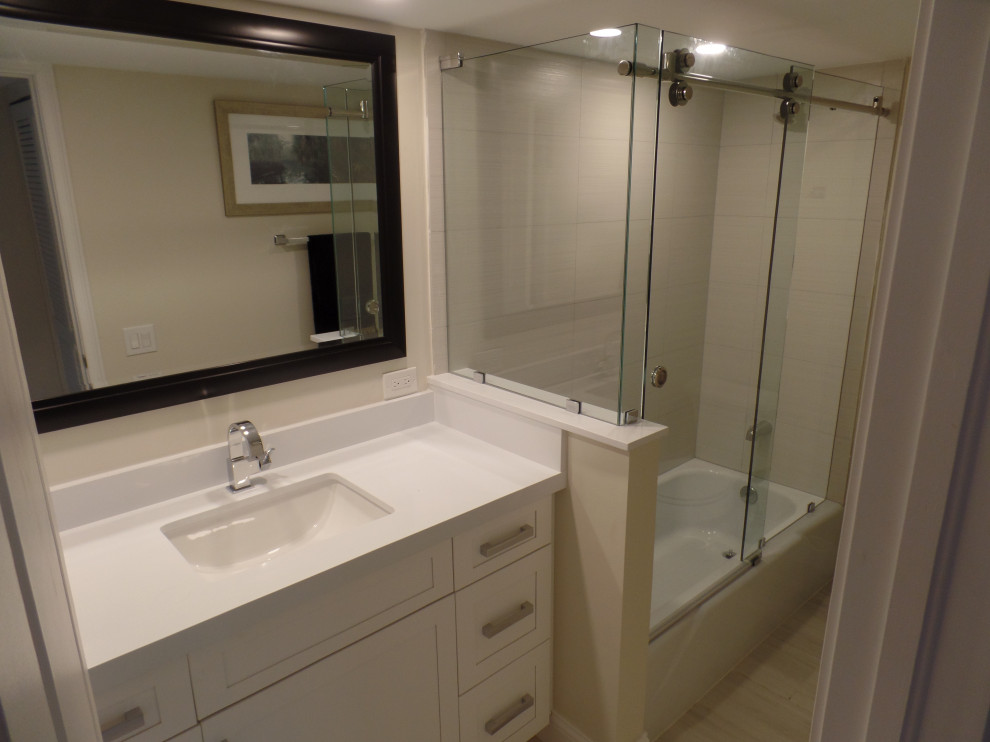 Example of a mid-sized minimalist beige tile and ceramic tile ceramic tile and gray floor bathroom design in Other with shaker cabinets, white cabinets, a two-piece toilet, beige walls, an undermount sink, quartzite countertops and white countertops