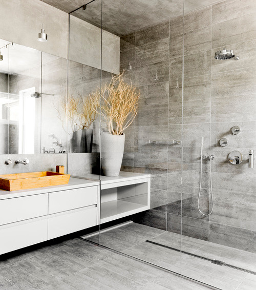 Exempel på ett mycket stort modernt badrum, med släta luckor, skåp i ljust trä, en öppen dusch, en vägghängd toalettstol, grå kakel, cementkakel, grå väggar, betonggolv, ett fristående handfat, träbänkskiva, grått golv och med dusch som är öppen
