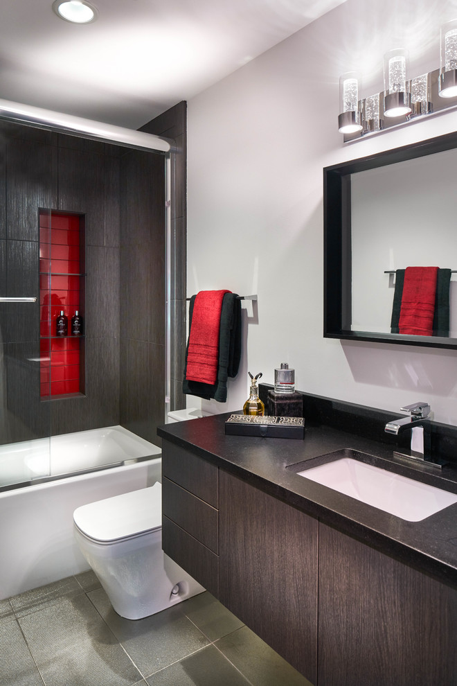 Modern inredning av ett mellanstort badrum med dusch, med släta luckor, bruna skåp, ett badkar i en alkov, en dusch/badkar-kombination, grå kakel, porslinskakel, vita väggar, klinkergolv i porslin, ett undermonterad handfat, granitbänkskiva, grått golv och dusch med skjutdörr