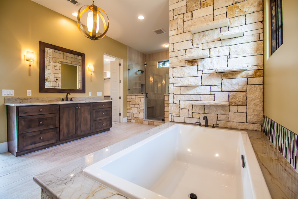 Design ideas for an expansive contemporary ensuite bathroom in Austin with shaker cabinets, dark wood cabinets, a built-in bath, an alcove shower, yellow walls, porcelain flooring, a submerged sink, marble worktops, beige floors and a hinged door.