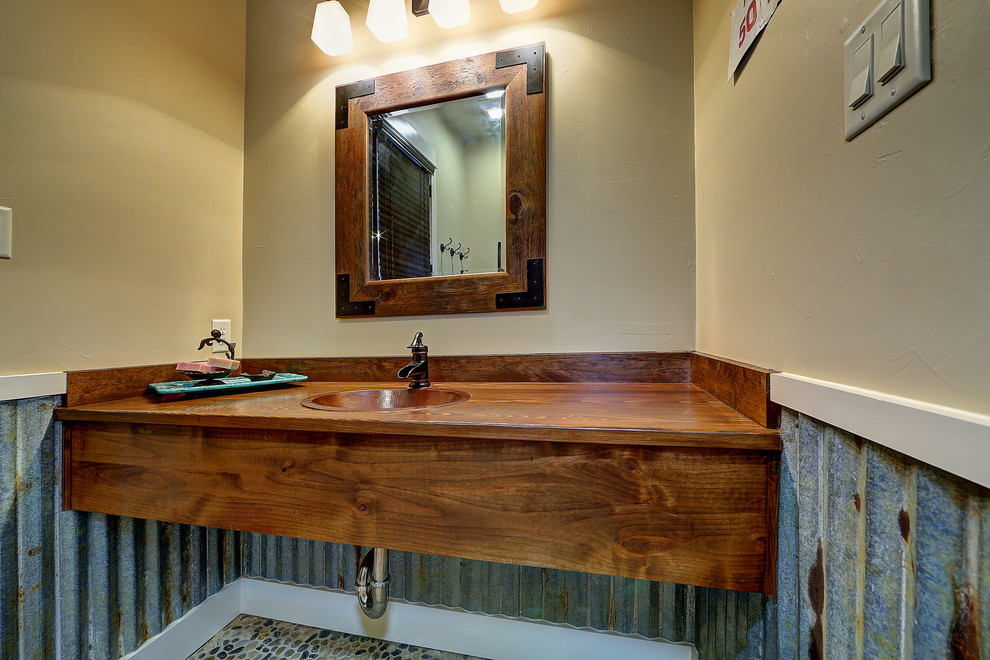 Foto de cuarto de baño rural con encimera de madera y suelo de baldosas tipo guijarro