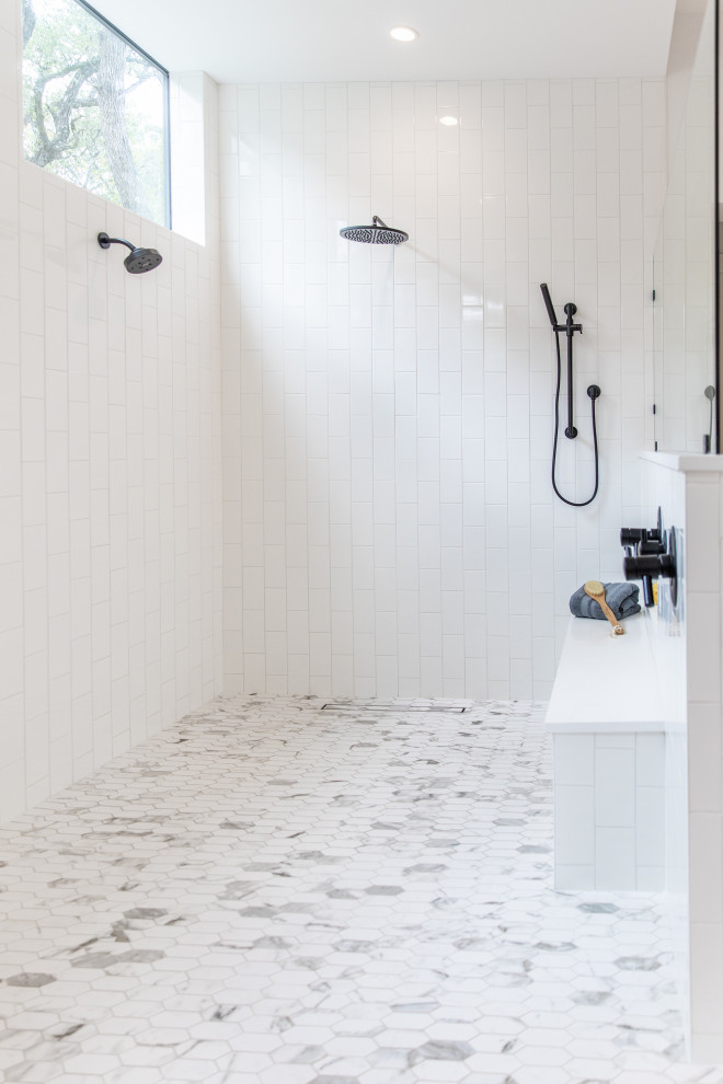 Inredning av ett modernt mycket stort svart svart en-suite badrum, med släta luckor, skåp i ljust trä, ett fristående badkar, en dubbeldusch, en toalettstol med separat cisternkåpa, vit kakel, stenkakel, vita väggar, klinkergolv i porslin, ett fristående handfat, granitbänkskiva, vitt golv och med dusch som är öppen