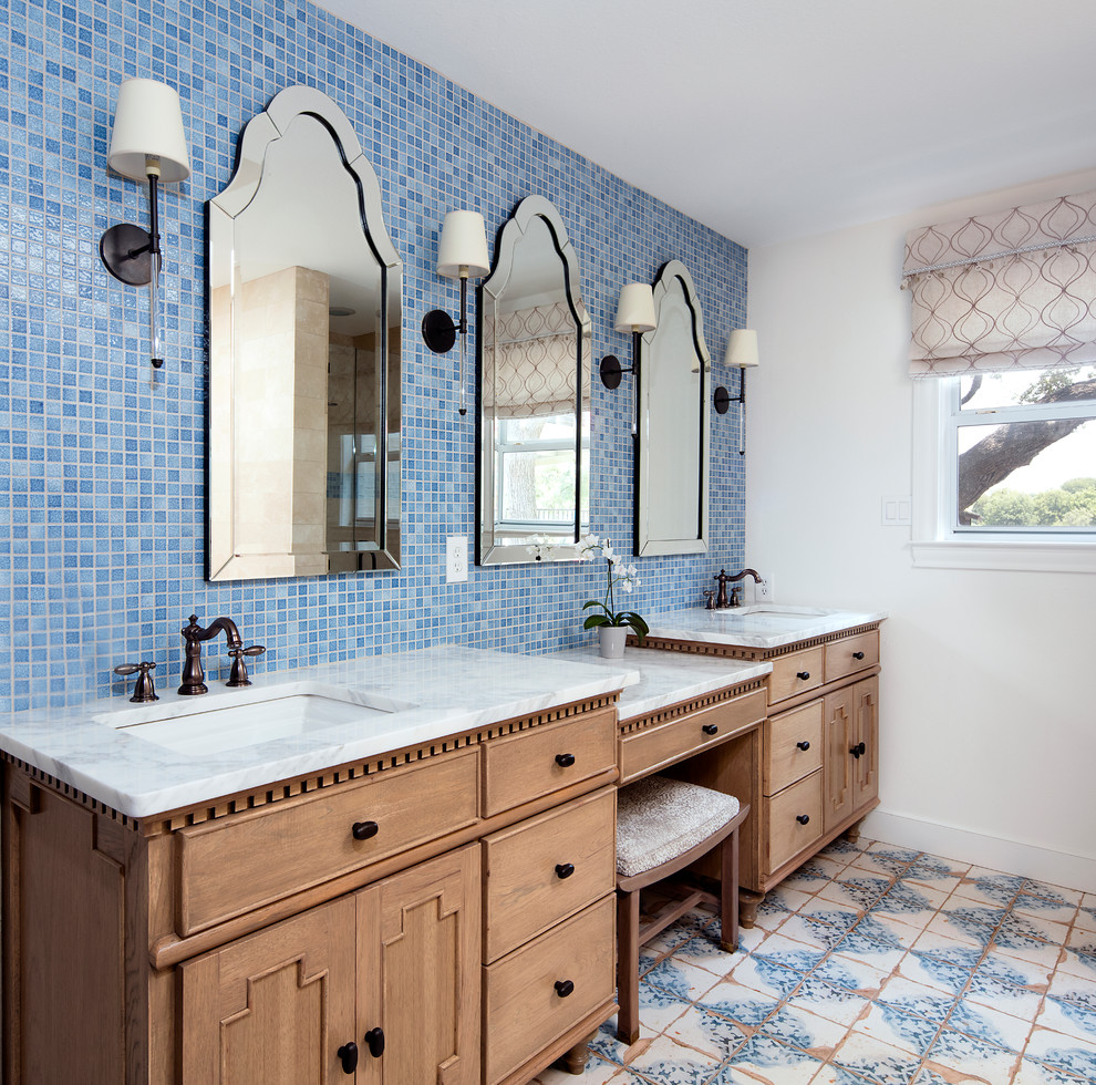 Cette image montre une salle de bain marine en bois brun avec un carrelage bleu, mosaïque, un mur blanc, un lavabo encastré, un sol multicolore, un plan de toilette blanc et un placard à porte plane.