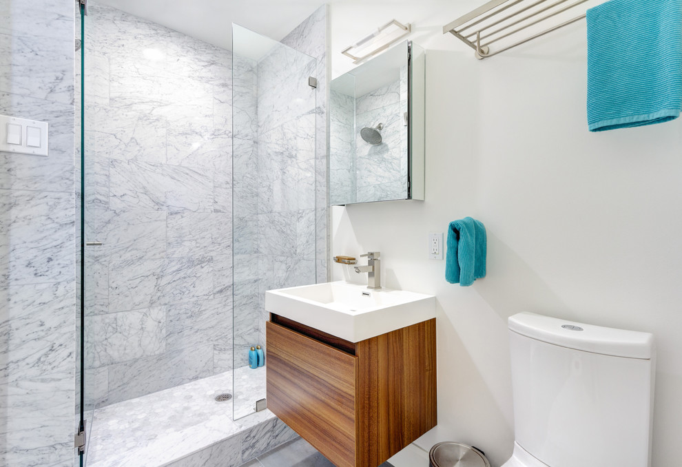 На фото: ванная комната в стиле неоклассика (современная классика) с подвесной раковиной, столешницей из искусственного камня, душем в нише, серой плиткой, каменной плиткой, белыми стенами и полом из керамогранита