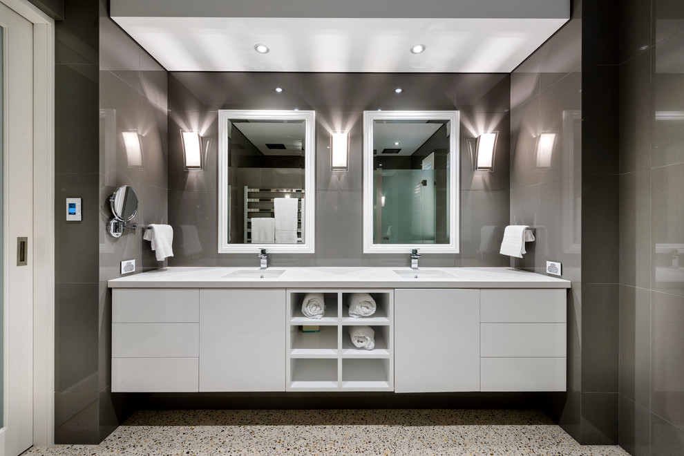 Esempio di una stanza da bagno padronale minimalista di medie dimensioni con ante lisce, ante bianche, piastrelle marroni, pavimento in cemento, lavabo sottopiano e top in quarzo composito