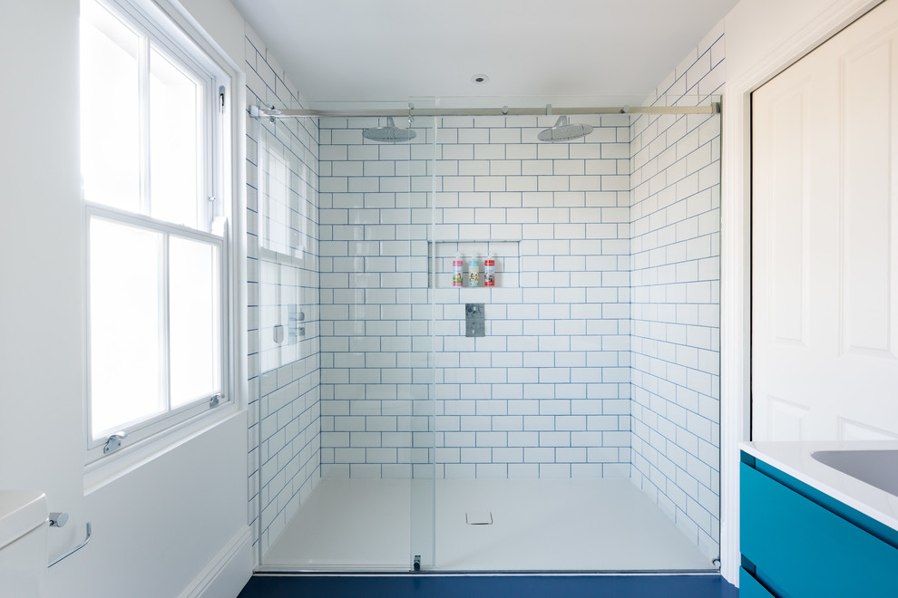 Идея дизайна: большая детская ванная комната в викторианском стиле с плоскими фасадами, синими фасадами, накладной ванной, открытым душем, инсталляцией, белой плиткой, керамогранитной плиткой, белыми стенами, полом из линолеума, монолитной раковиной, столешницей из кварцита, синим полом, душем с раздвижными дверями и белой столешницей