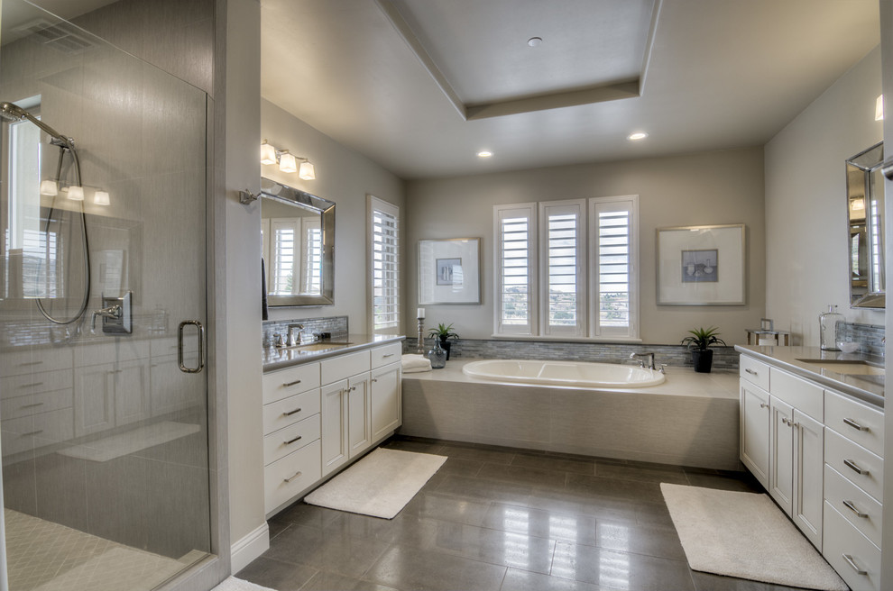 Large trendy master gray tile and stone tile dark wood floor and brown floor bathroom photo in Sacramento with recessed-panel cabinets, white cabinets, beige walls, an undermount sink, granite countertops and a hinged shower door