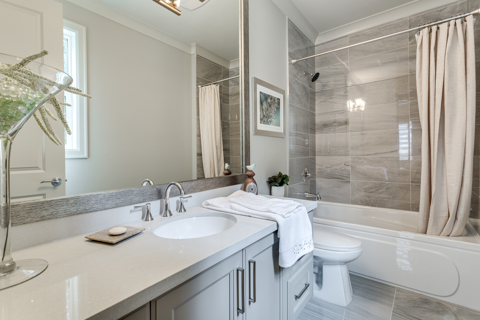 Design ideas for a traditional shower room bathroom in Vancouver with grey cabinets, an alcove bath, a shower/bath combination, a one-piece toilet, multi-coloured tiles, grey walls, a submerged sink, multi-coloured floors and a shower curtain.
